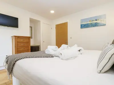 a bedroom with a white bed with towels on it at Beech in Truro