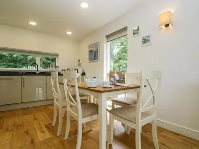 a kitchen and dining room with a wooden table and chairs at Ash in Truro