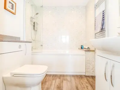 a white bathroom with a toilet and a sink at The Crest in Helston