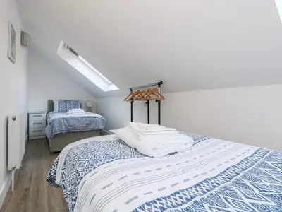 a bedroom with a bed with a blue and white blanket at The Crest in Helston
