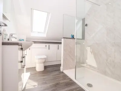 a bathroom with a shower and a sink and a toilet at The Crest in Helston