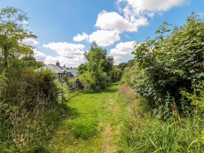 a path through the garden of a house at Manor House Barn in Camelford