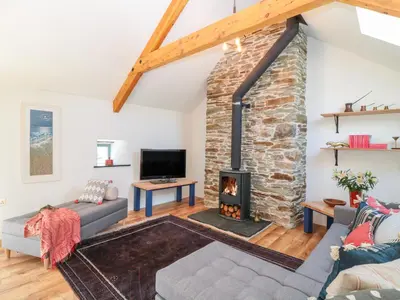 a living room with a fireplace and a tv at Manor House Barn in Camelford