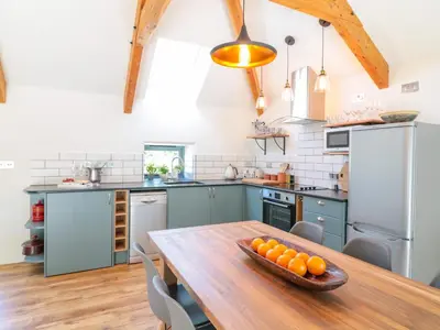 a kitchen with a wooden table with a bowl of oranges on it at Manor House Barn in Camelford