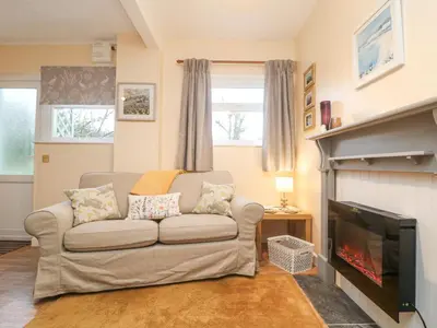 a living room with a couch and a fireplace at The Roost in Camborne