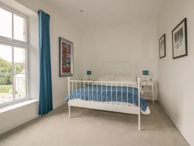 a white bed in a white room with a window at Cherrywood Manor in Bodmin