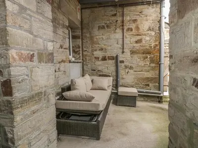 a couch sitting in a brick walled room at Cherrywood Manor in Bodmin