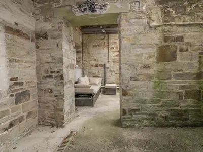 a room with a couch in a brick wall at Cherrywood Manor in Bodmin