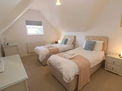 a attic bedroom with two beds and a window at Meridian in St Ives