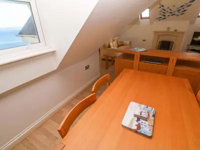 a dining room with a wooden table and a window at Meridian in St Ives