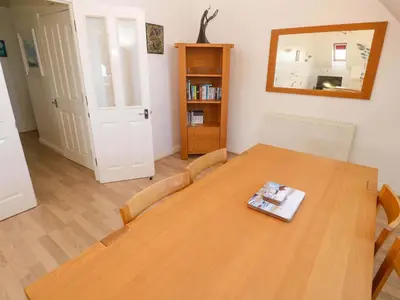 a dining room with a wooden table and a mirror at Meridian in St Ives