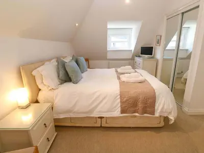 a bedroom with a large bed in a attic at Meridian in St Ives