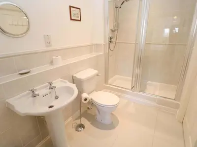 a bathroom with a toilet and a shower and a sink at Meridian in St Ives