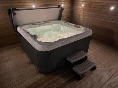 a hot tub in a room with two stools in it at Willow, Retallack in Saint Columb Major