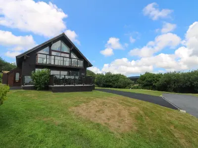 a house on a grassy hill with a road at Willow, Retallack in Saint Columb Major
