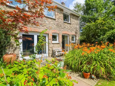 a stone house with a garden in front of it at Coth Skyber in Hayle