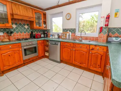 a kitchen with wooden cabinets and a sink at Coth Skyber in Hayle
