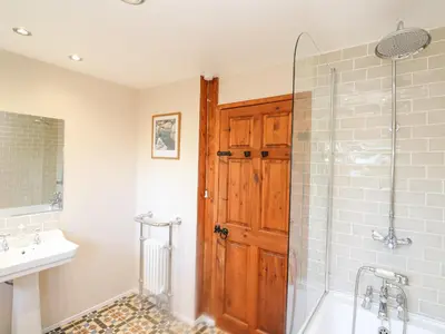 a bathroom with a shower and a wooden door at Coth Skyber in Hayle