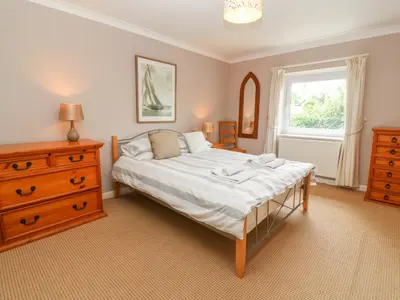 a bedroom with a bed and a dresser and a window at Coth Skyber in Hayle