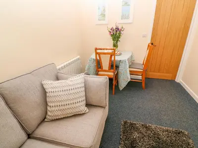 a living room with a couch and a table at The Old Cows House in Helston
