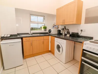 a kitchen with a washing machine and a washer at The Old Cows House in Helston