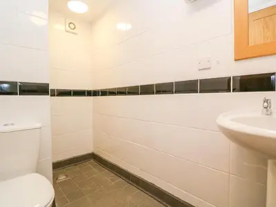 a bathroom with a toilet and a sink at The Old Cows House in Helston