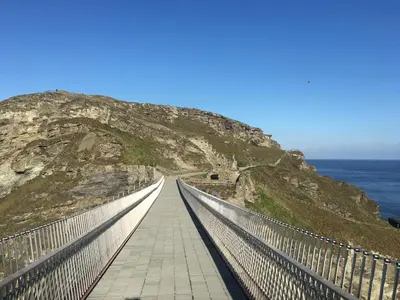 a bridge on the side of a mountain next to the ocean at Copthorne - Tintagel in Tintagel