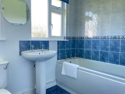a bathroom with a sink and a bath tub and a mirror at Copthorne - Tintagel in Tintagel