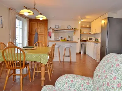 a kitchen and dining room with a table and a refrigerator at Roadstead in Fowey