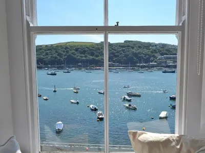a window with a view of a body of water with boats at Roadstead in Fowey