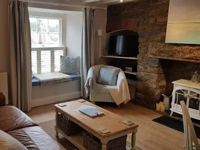 a living room with a couch and a fireplace at Below Deck in Fowey