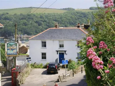 a white house with a car parked in front of it at Below Deck in Fowey