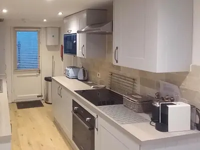a kitchen with white cabinets and a counter top at Below Deck in Fowey