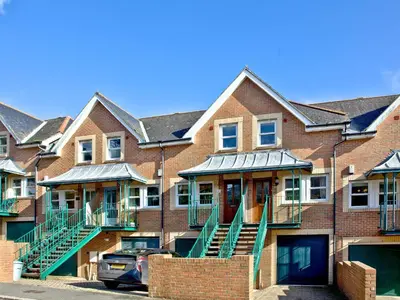 a row of brick houses with green stairs and a car at Chyandour in Fowey