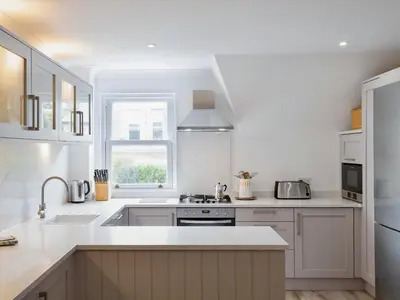 a white kitchen with a stove and a sink at Chyandour in Fowey