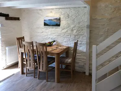 a dining room with a wooden table and chairs at Cider Press Cottage in Fowey