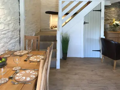 a dining room with a wooden table with wine glasses at Cider Press Cottage in Fowey