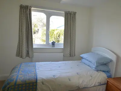 a bedroom with a bed and a window at Riverview in Fowey