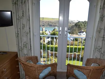 two chairs in front of a door with a view at Riverview in Fowey