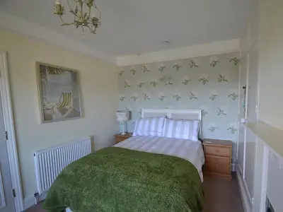 a bedroom with a bed with a green blanket at Riverview in Fowey