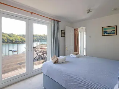 a bedroom with a bed and a large window at Lower Deck in Fowey