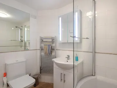 a bathroom with a toilet and a sink and a shower at Lower Deck in Fowey