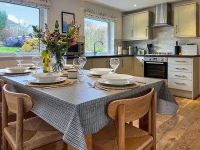 a kitchen with a table with chairs and a tableablish at The Lodge in Fowey