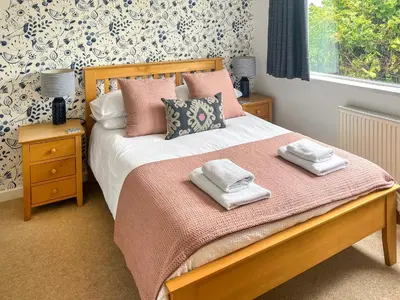 a bedroom with a bed with two towels on it at The Lodge in Fowey