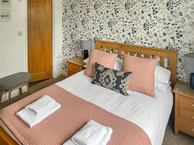 a bedroom with a bed with pink and white pillows at The Lodge in Fowey