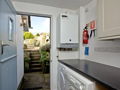 a kitchen with a washing machine and a window at The Lodge in Fowey