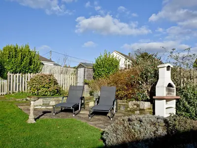 two chairs and a table in a yard at The Lodge in Fowey