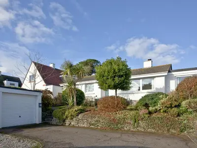 a white house with a garage and palm trees at The Lodge in Fowey