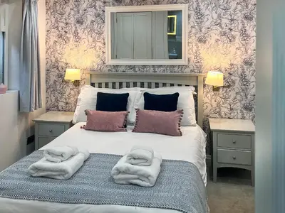 a bedroom with a bed with towels on it at St Monicas in Fowey