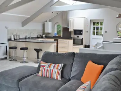 a living room with a couch and a kitchen at St Monicas in Fowey